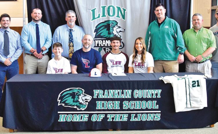 Lion senior Keilin Sanders (seated center) is pictured with his family – father Lyles Sanders, mother Crystal Sanders and brother Talon Sanders – and coaches from Franklin County High School, Franklin County Middle School and travel ball team Line Drive Academy during his signing ceremony Monday at FCHS. (Photo by Scoggins)